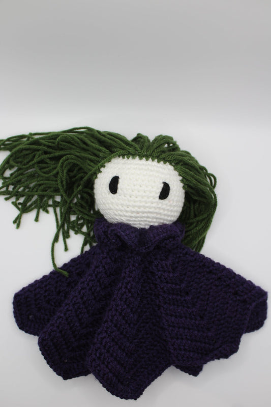 Crochet baby lovey with green hair, white face, and purple blanket.