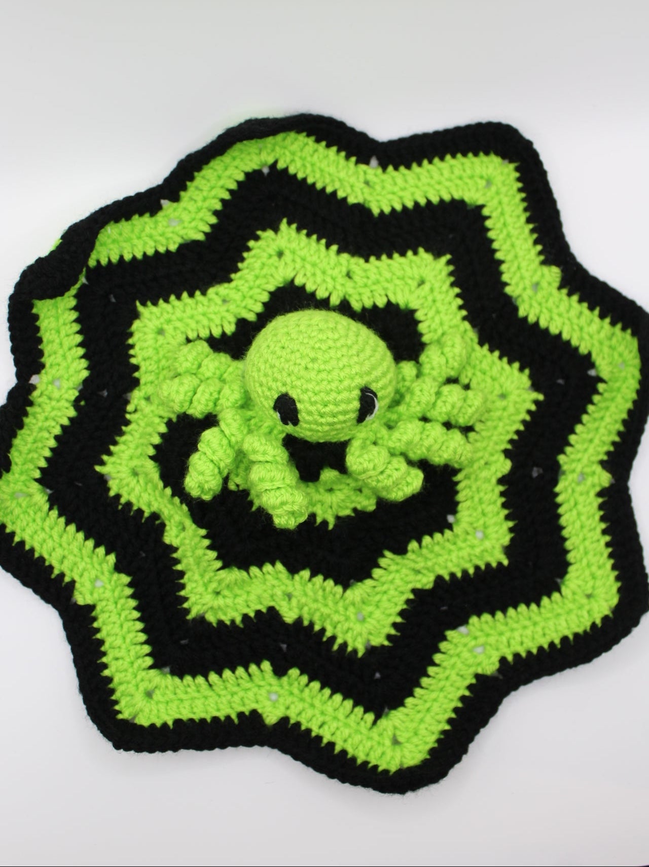 Crocheted item with green and black pattern on a white background